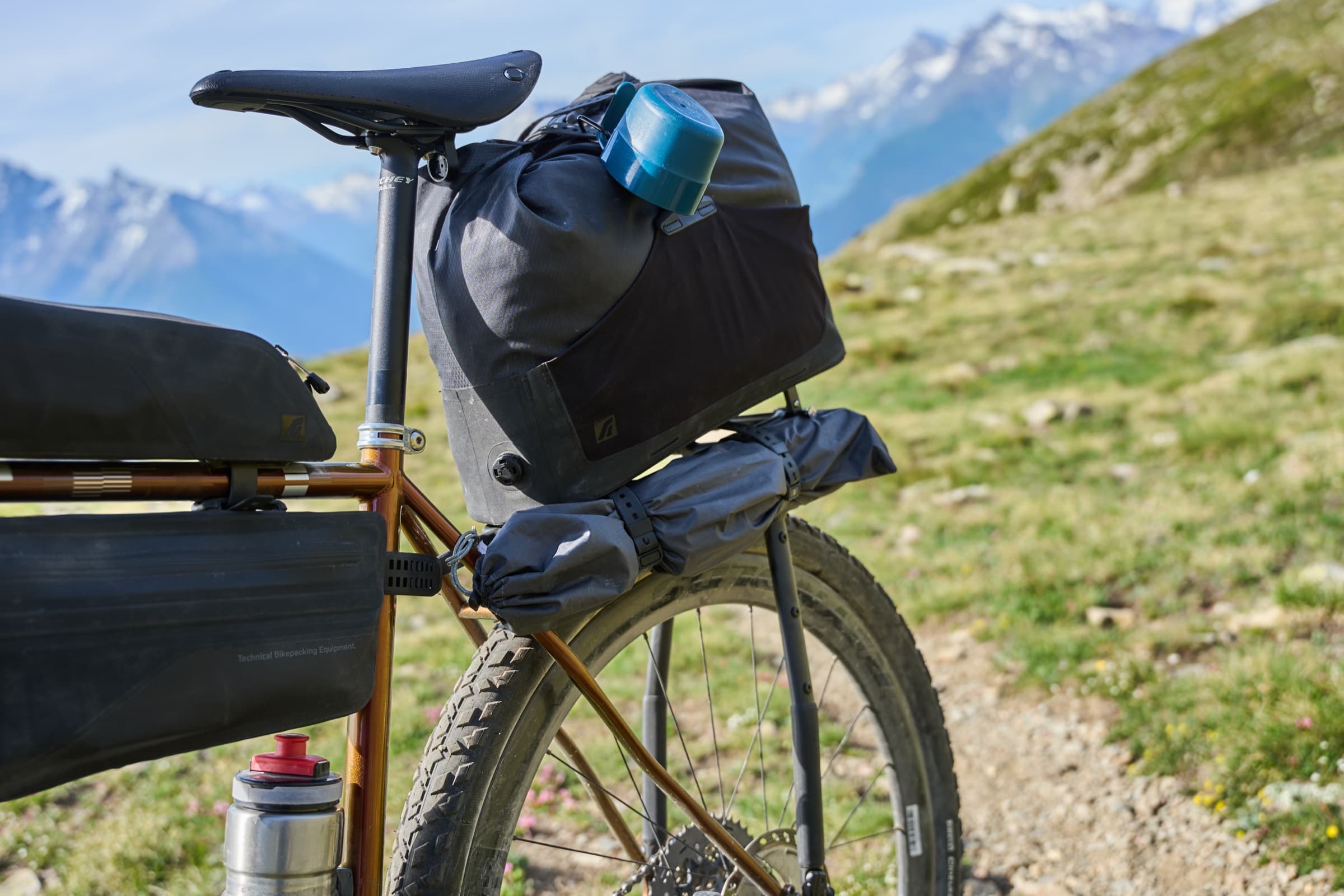 The rack's front connector bracket and seatpost clamp detail, mountains in the background.