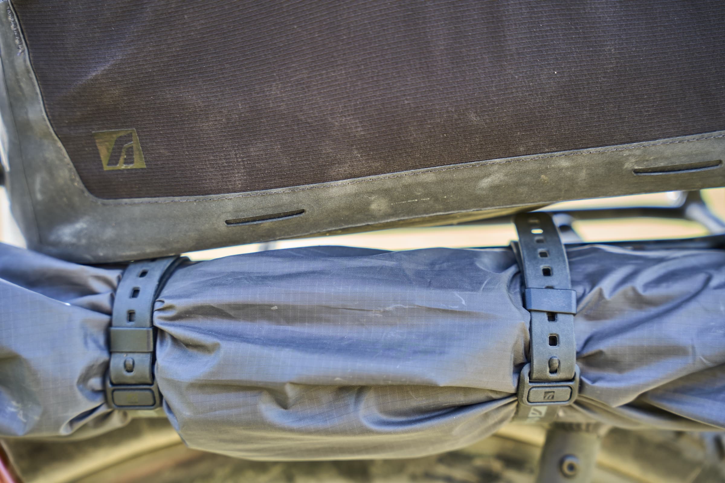 Close-up of a rack strap cinched around a stuffed dry bag.