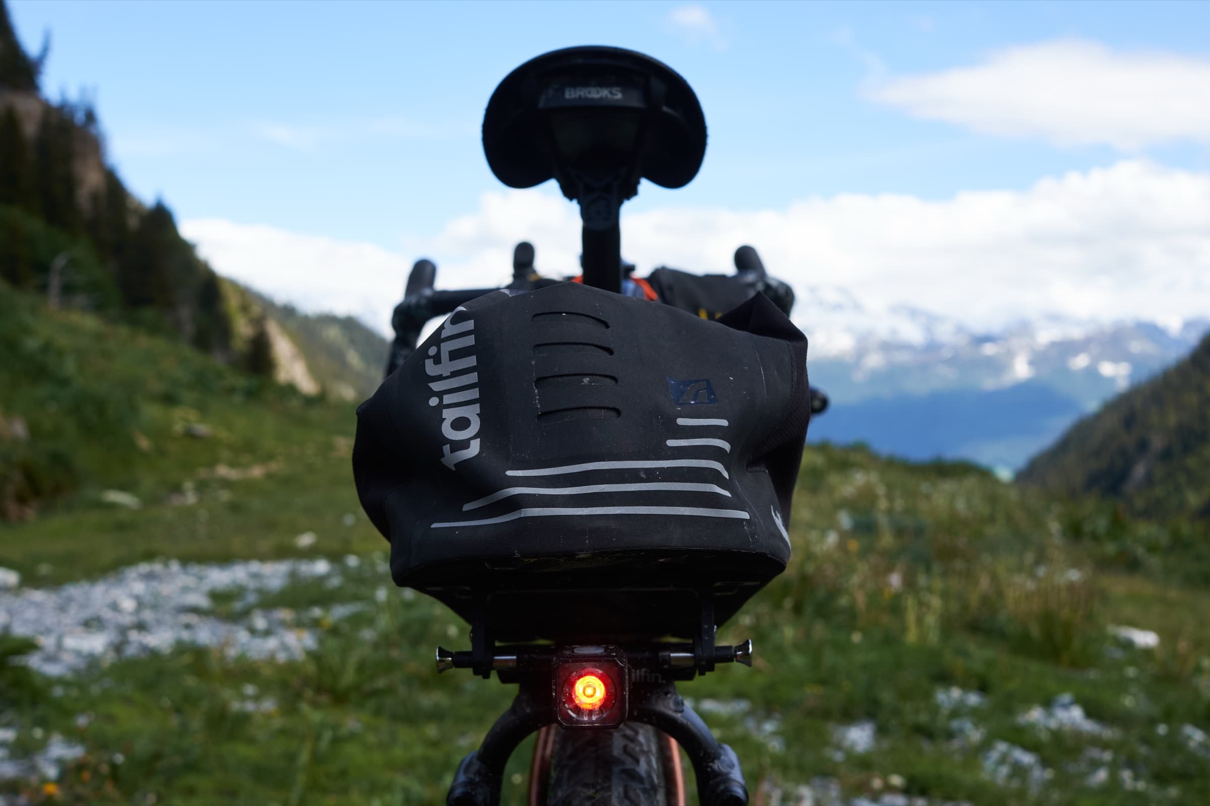 The Tailfin CargoPack mounted on the rack, shot from behind against the mountains.