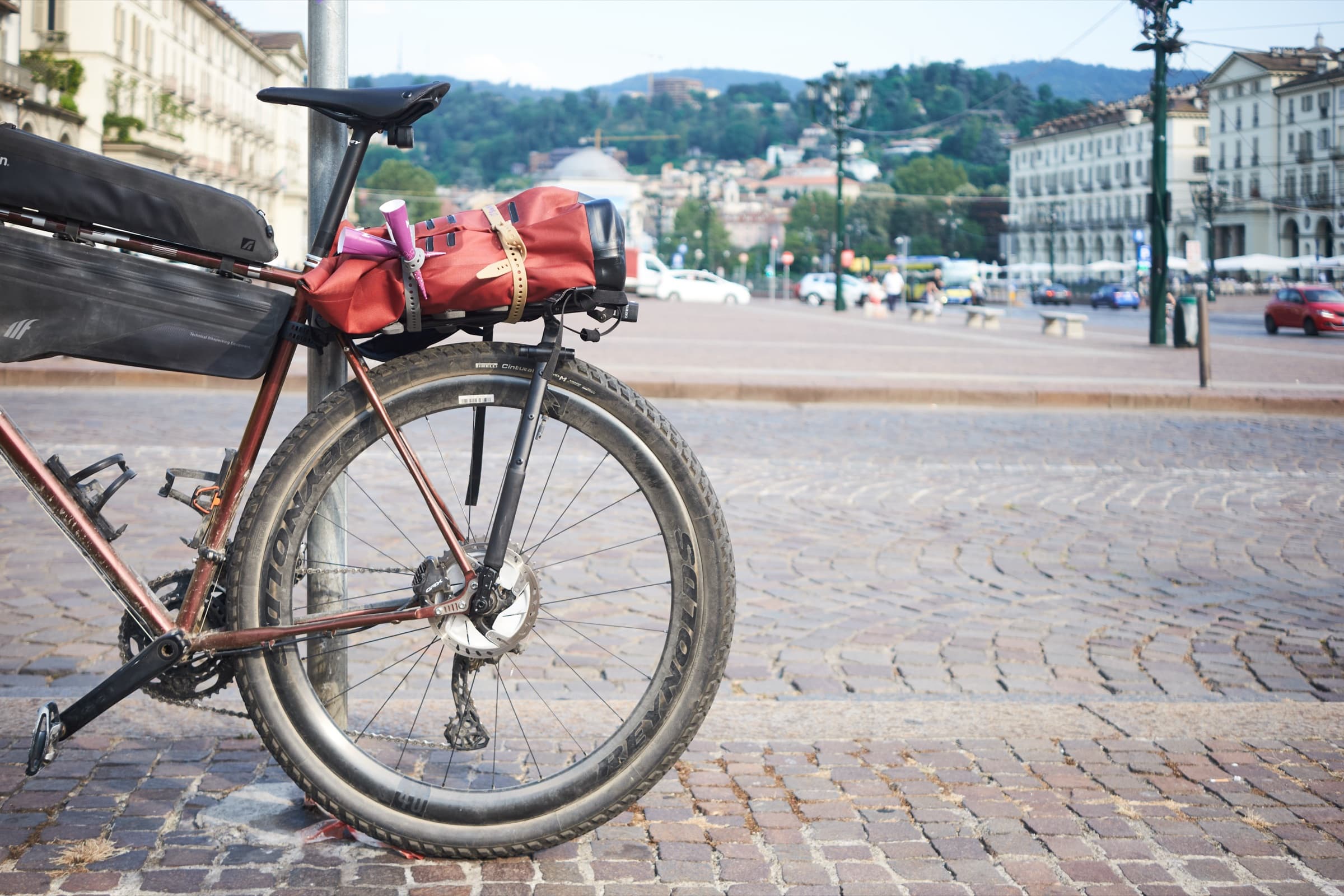 The loaded bike parked in a piazza in Turin, a red bag lashed to the rack.