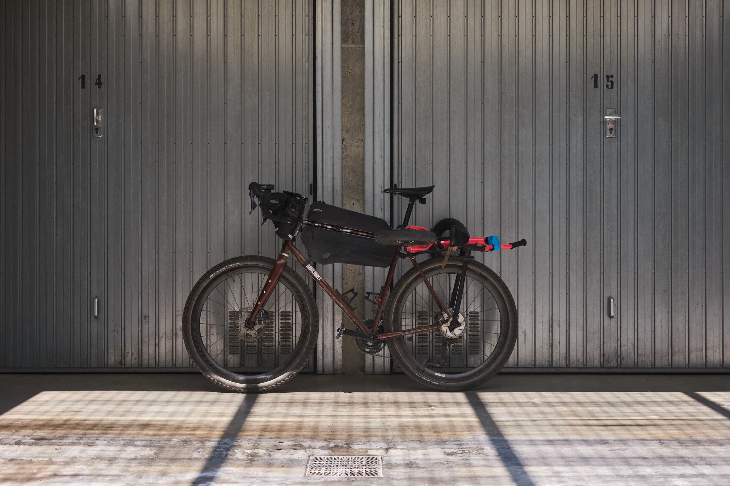 The bike leaned against corrugated garage doors, stripped down between trips.