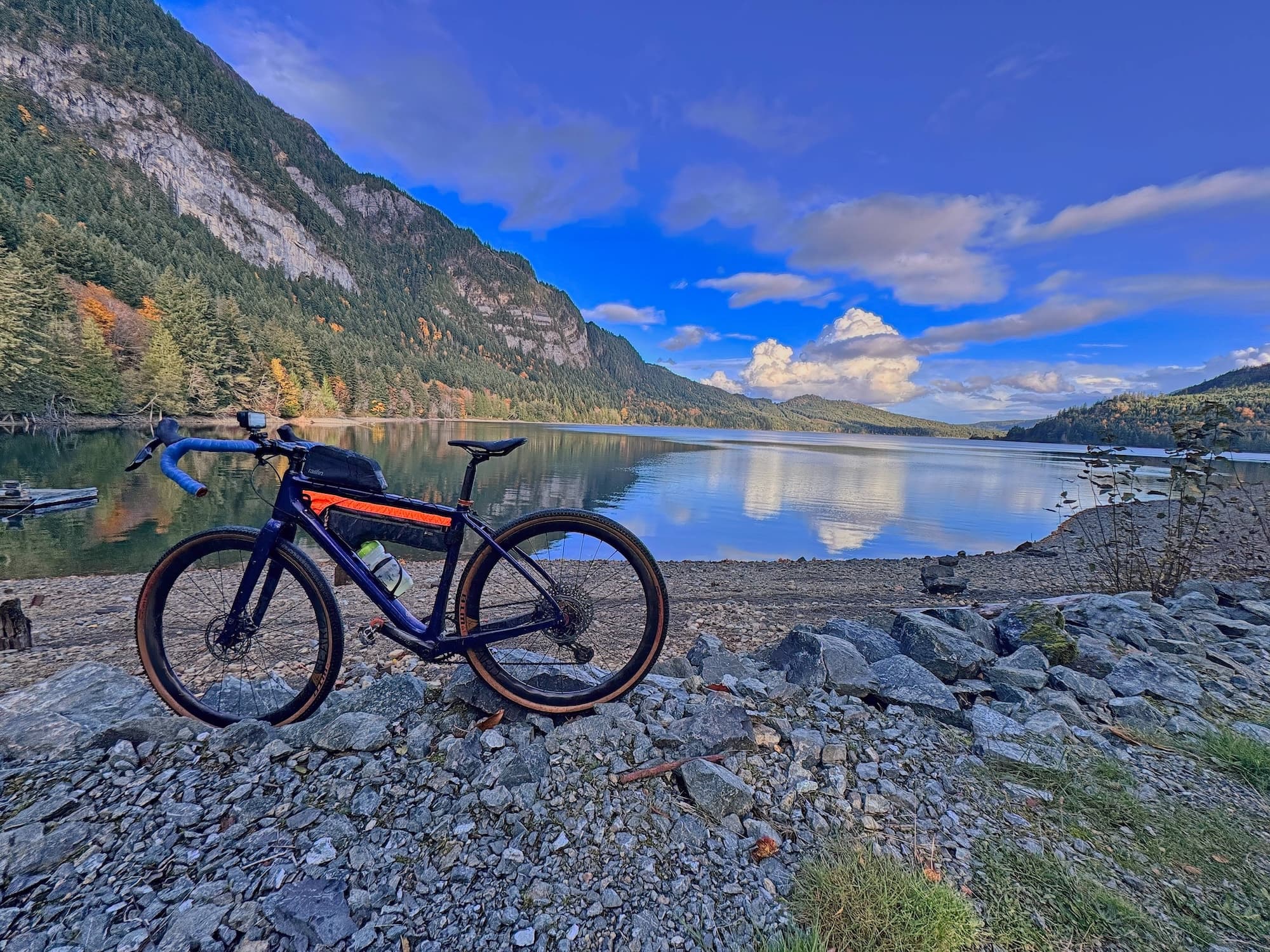 A gravel bike at the shore of Horne Lake beneath the cliffs of Mount Mark