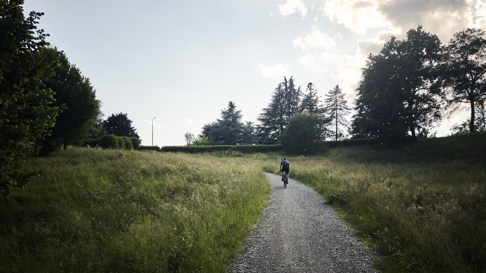 A solitary rider on gravel at dusk