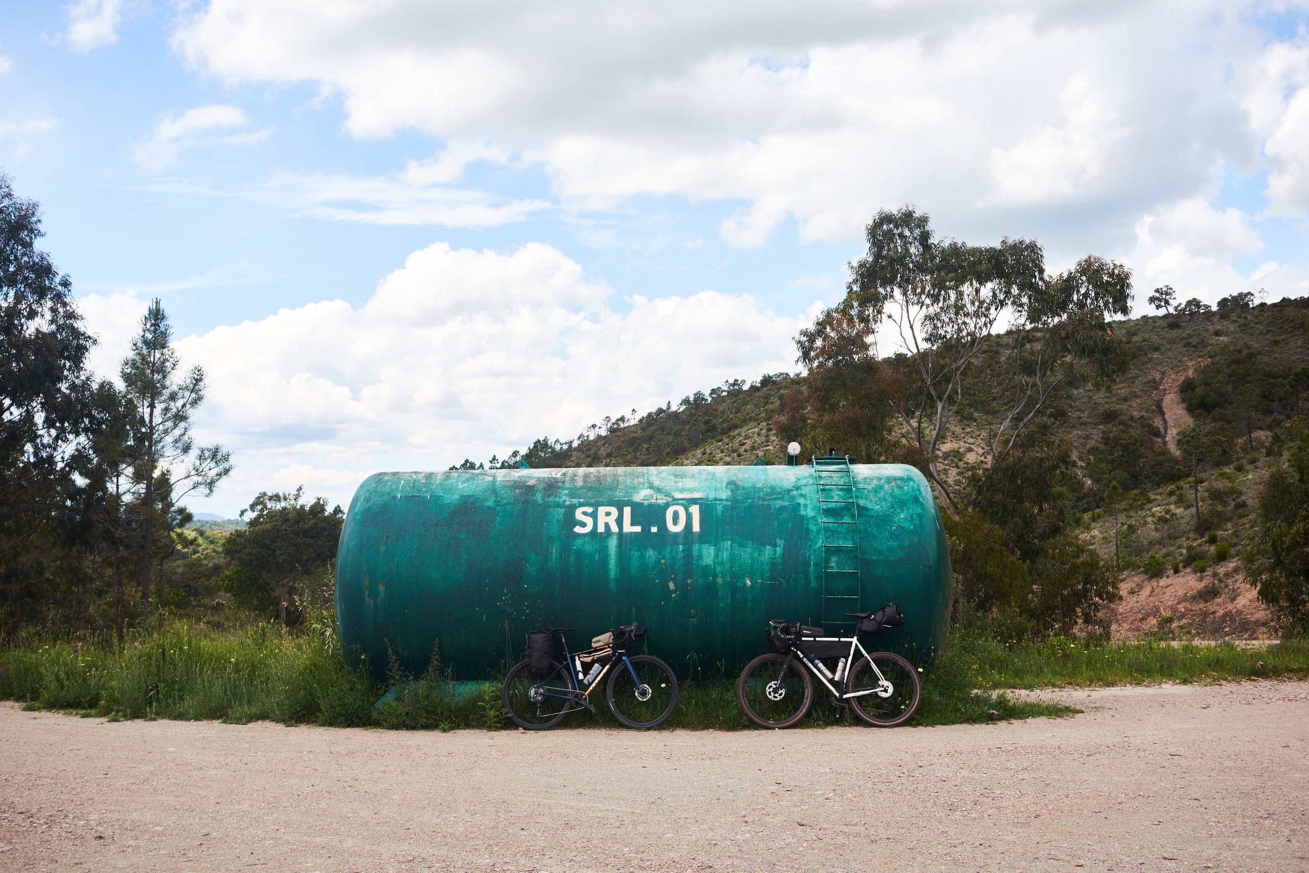 Loaded bikes leaned against a roadside water tank