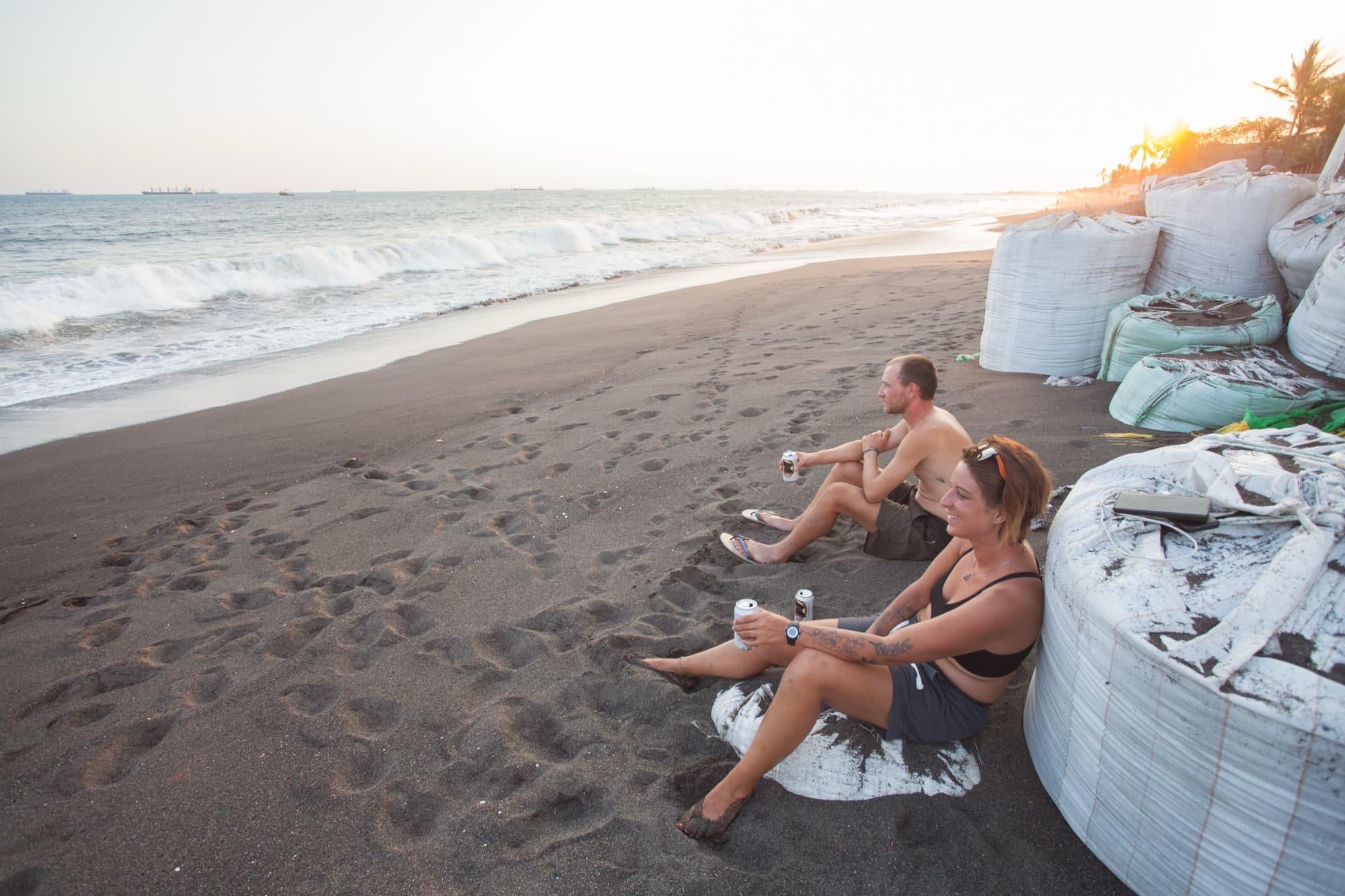 The brothers resting on a black sand beach by the surf