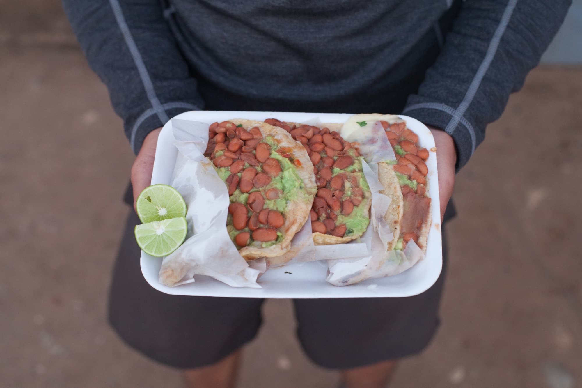 A plate of bean tostadas with lime, fresh from a street stand