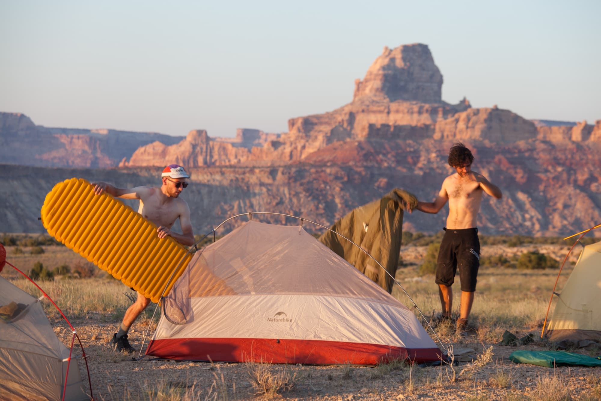 Setting up camp at sunset below desert towers