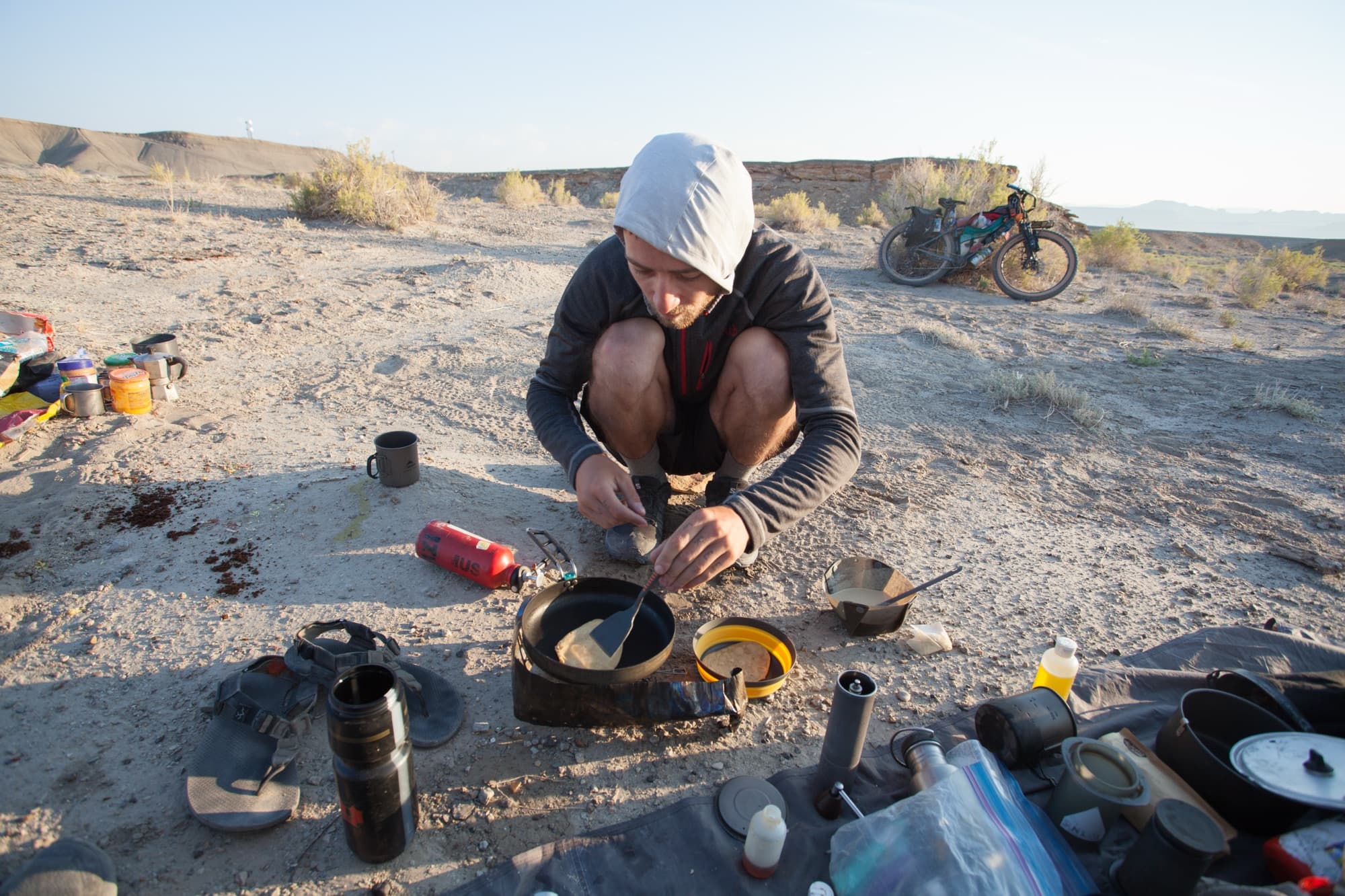 Cooking on the ground at dawn among the camp chaos