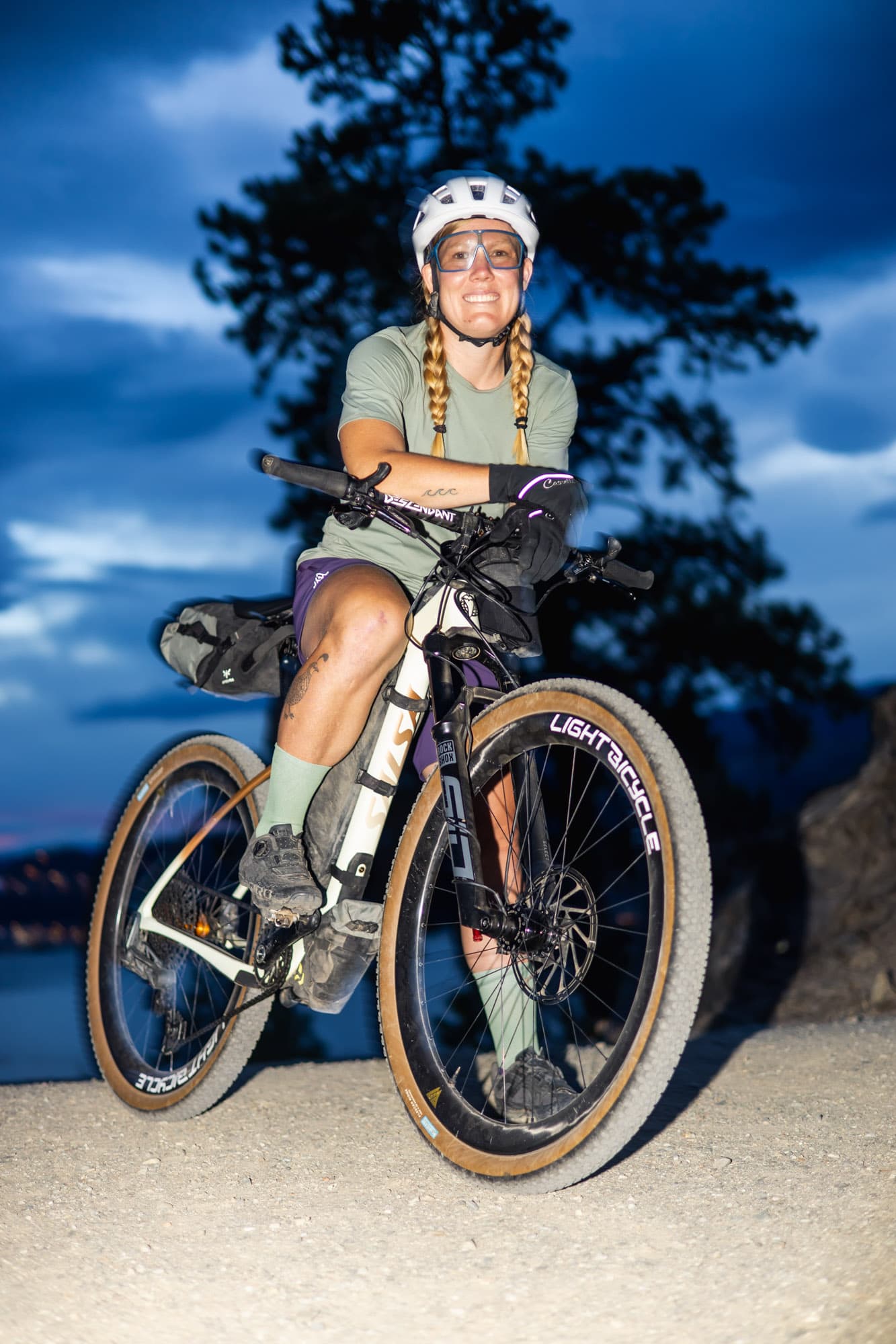 Meaghan with her bikepacking rig at blue hour.