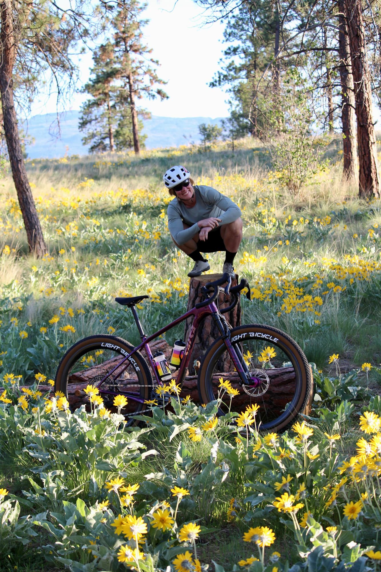 Meaghan riding through a meadow of balsamroot.