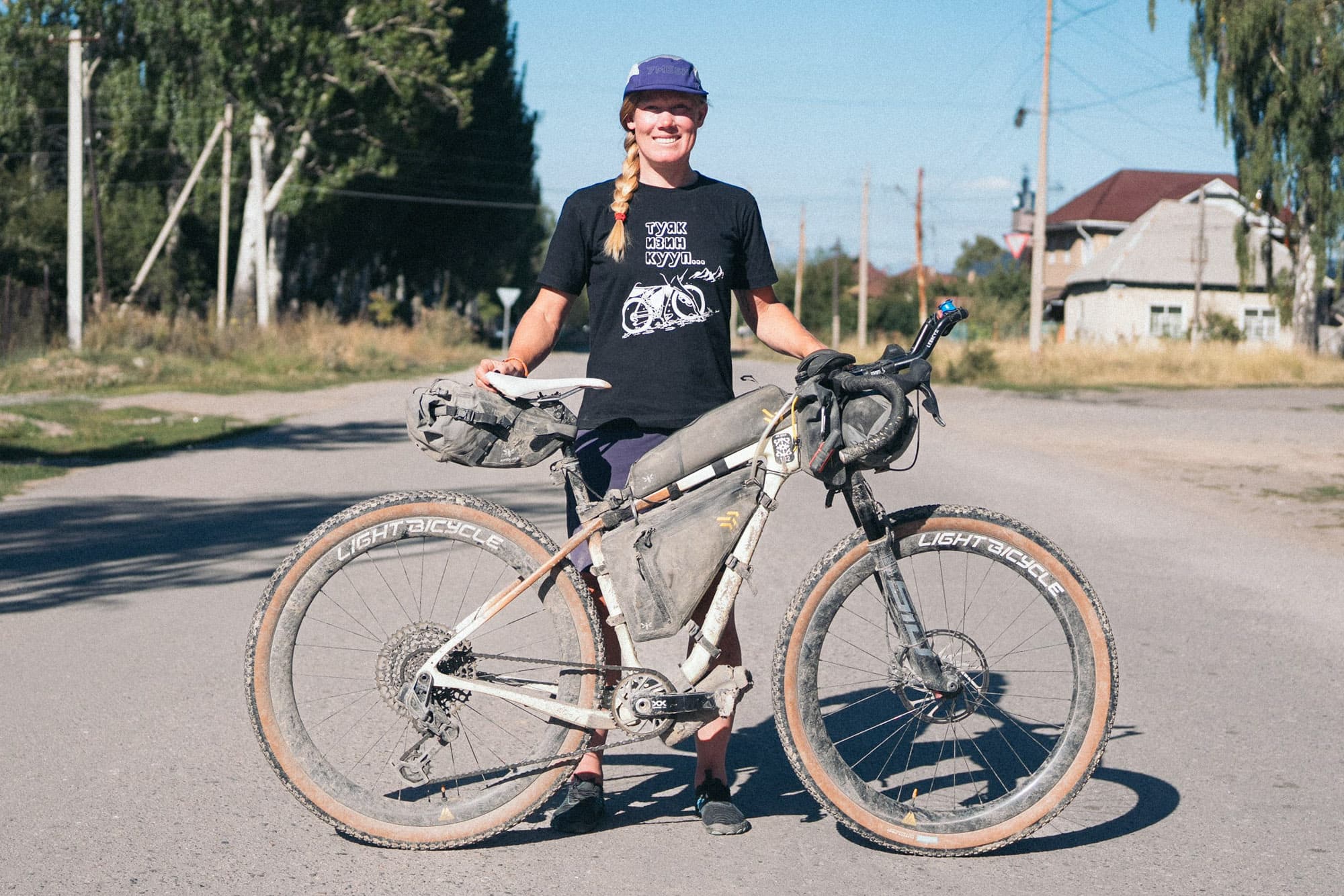 Meaghan with a loaded touring bike on a quiet street.