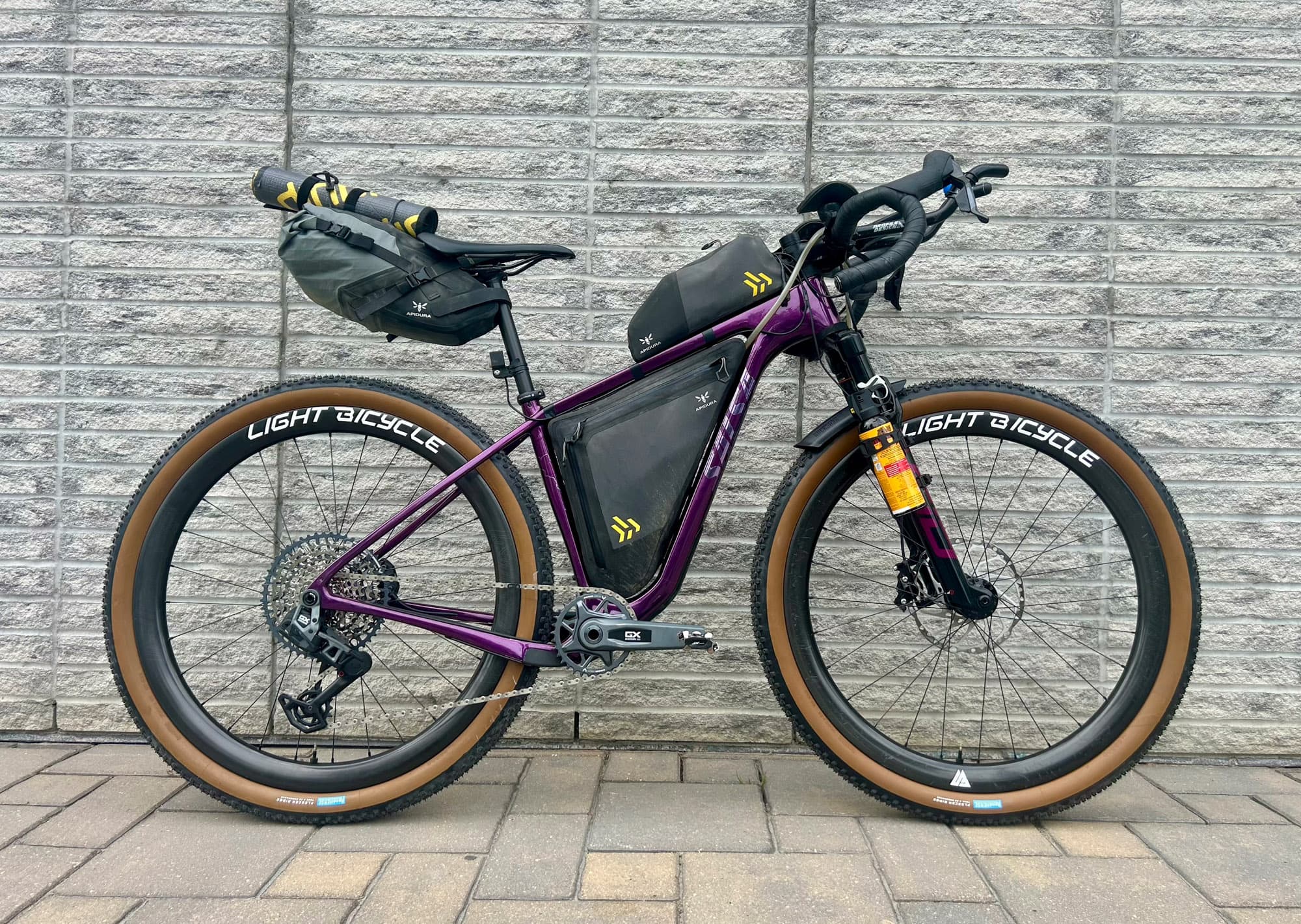 The Cutthroat loaded with bikepacking bags against a concrete wall.