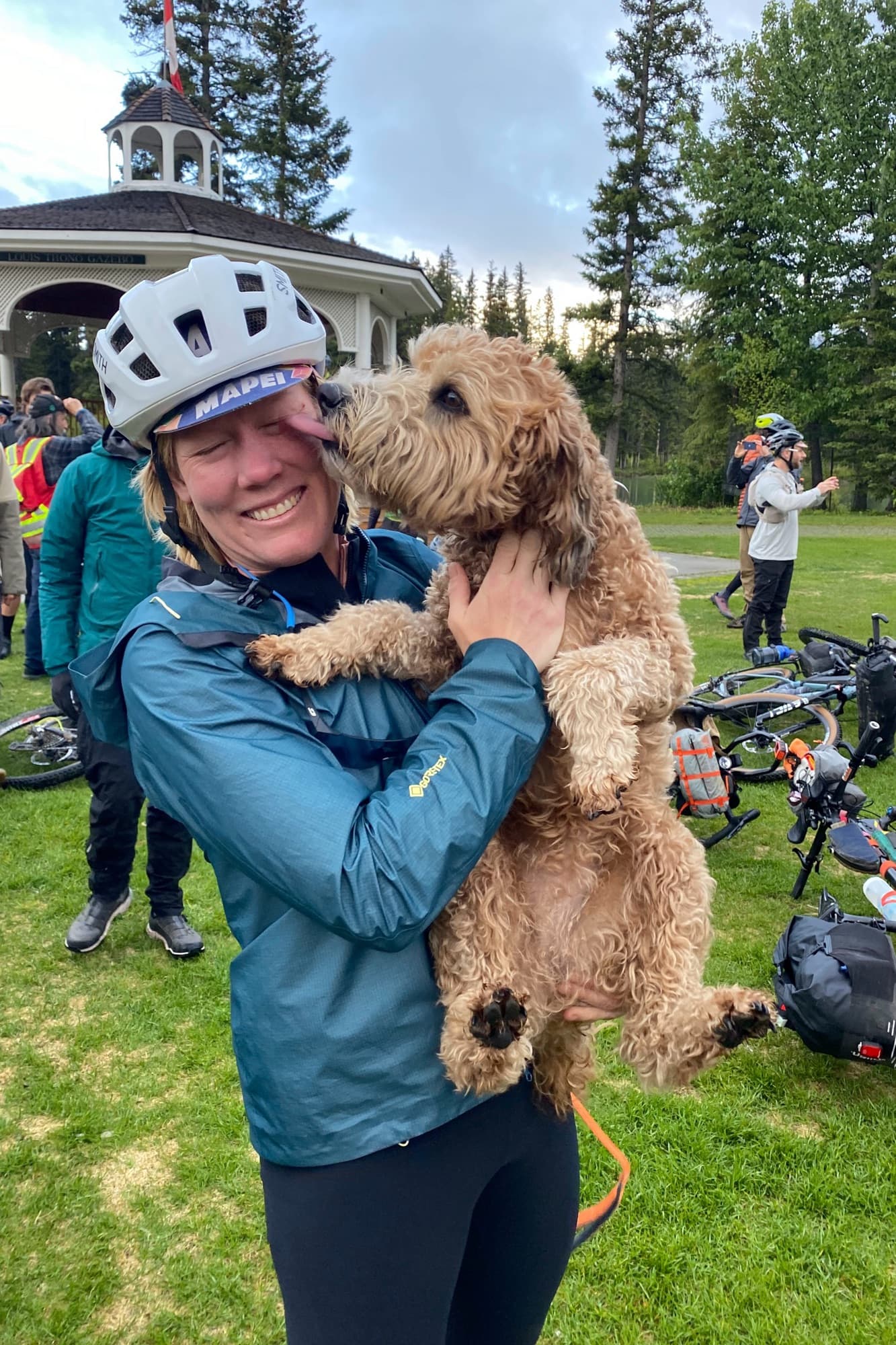 Meaghan gets a face lick from a friendly dog at the Divide Collective meetup in Banff's Central Park