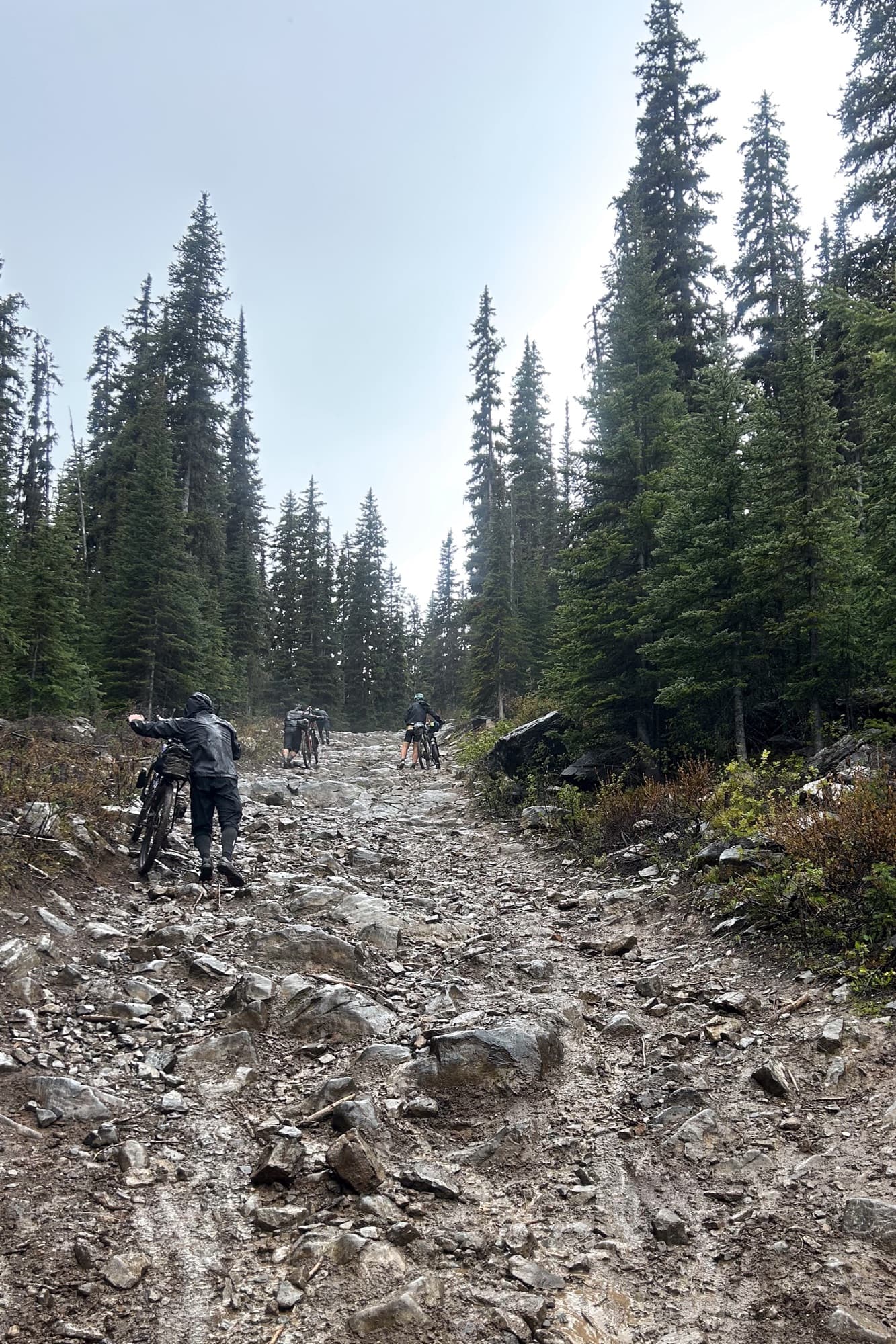 Riders push their bikes up the rocky Koko Claims hike-a-bike