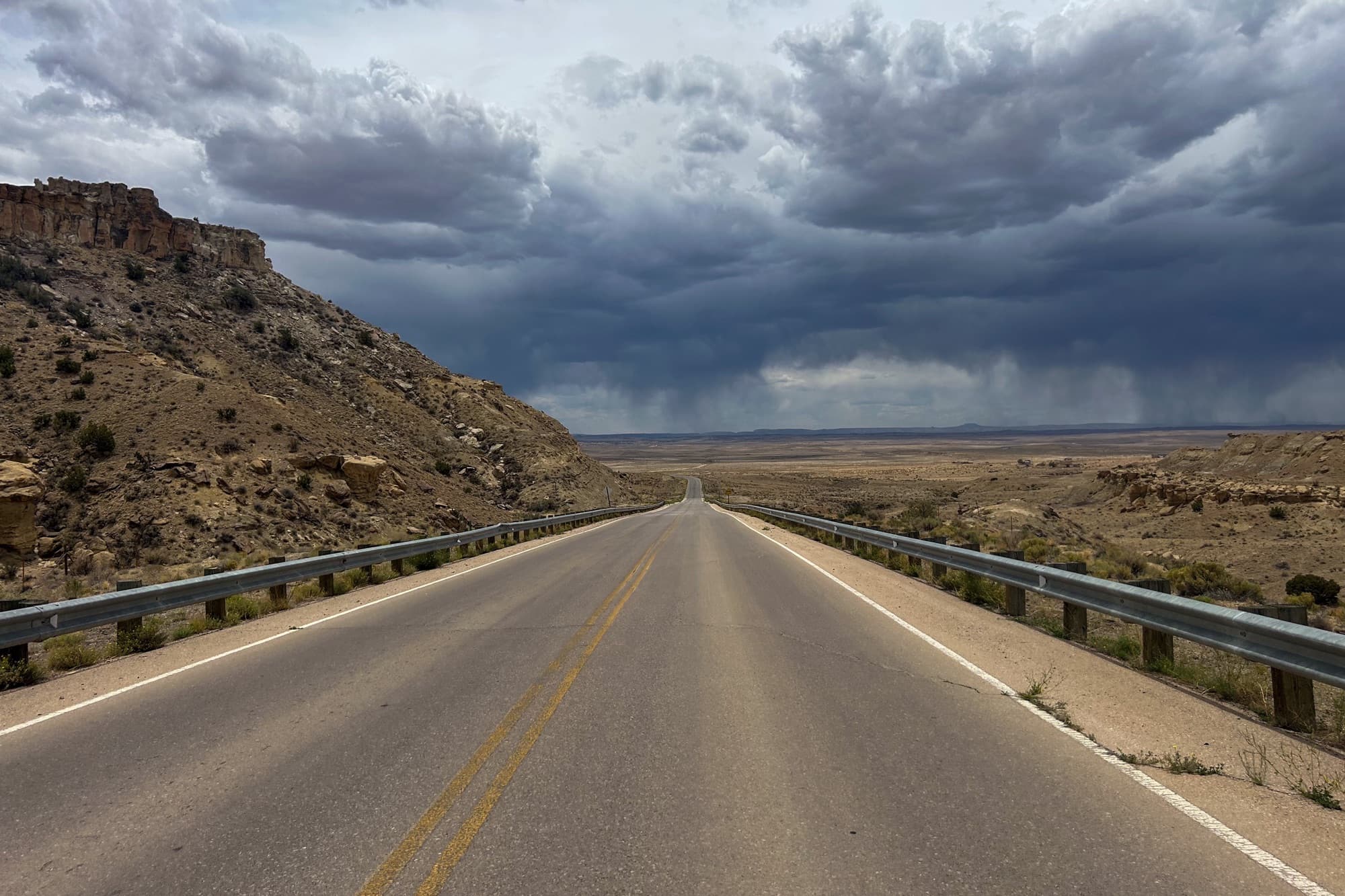 The final stretch of pavement points into a New Mexico storm