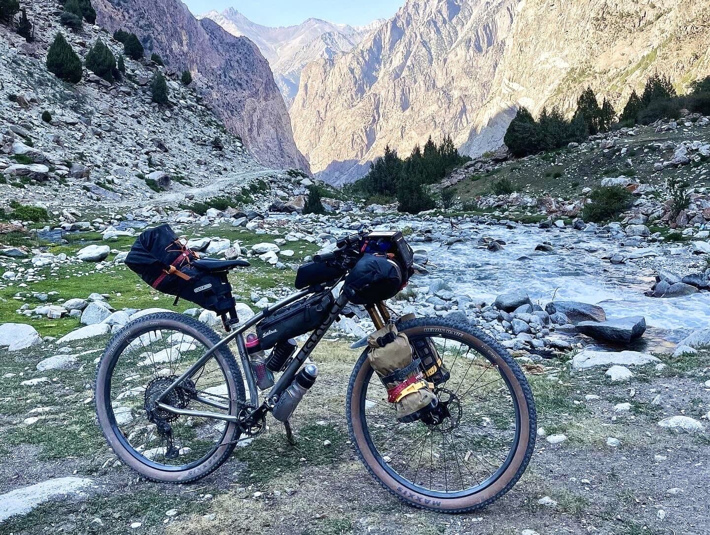 Britt's Naked titanium hardtail beside a glacial river on the climb to Jiptik Pass in the Pamir Alay.